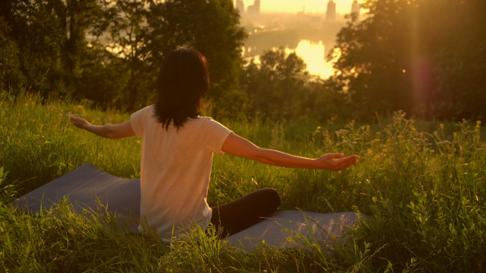 A figure greeting the sunset light — Awaken ecstatic dance